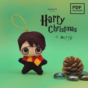 May include: A felt Harry Potter Christmas ornament. The ornament is a cartoon-like figure with a lightning bolt scar, round glasses, and a red and gold scarf. The text "Harry Christmas No. 1" is visible.