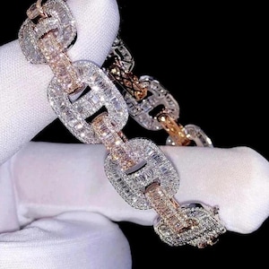 Könnte beinhalten: Nahaufnahme eines Diamantarmbands mit Kettenglied-Design. Das Armband kombiniert Weiß- und Roségold, wobei jedes Glied mit funkelnden Diamanten besetzt ist. Der schwarze Hintergrund hebt den Schmuck hervor.