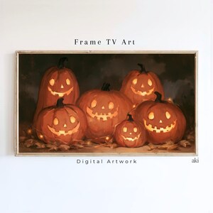 May include: Digital artwork titled Frame TV Art featuring five glowing jack-o'-lanterns with carved faces set against a dark background. The orange pumpkins are illuminated from within, resting on a bed of fallen autumn leaves.