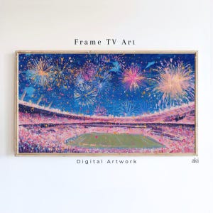 May include: Framed digital artwork showing a stadium with a green pitch, spectators, and a colourful fireworks display against a dark blue sky. The artwork is labelled "Frame TV Art" and "Digital Artwork".