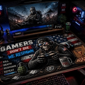 May include: Gaming setup featuring a large monitor displaying a war scene, a gaming PC, and a desk mat with a skull graphic wearing sunglasses and holding a controller. The mat reads "Gamers Don't Die, We Respawn."