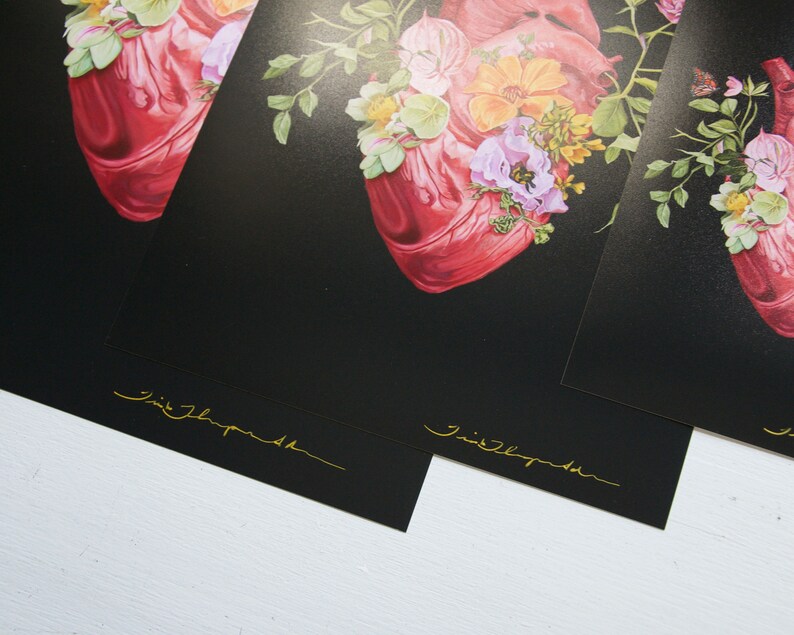 May include: Three black and white prints of a red anatomical heart with floral accents. The prints are signed "Jimi Thompson" in gold lettering.