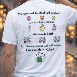 Könnte beinhalten: Weißes T-Shirt mit schwarzem Text und Cartoon-Illustrationen. Der Text lautet: "Mir egal welche Hautfarbe du hast...wie schwer du bist...oder wen du liebst. Ich hab einfach keine Lust auf Menschen. Lass mich in Ruhe!"