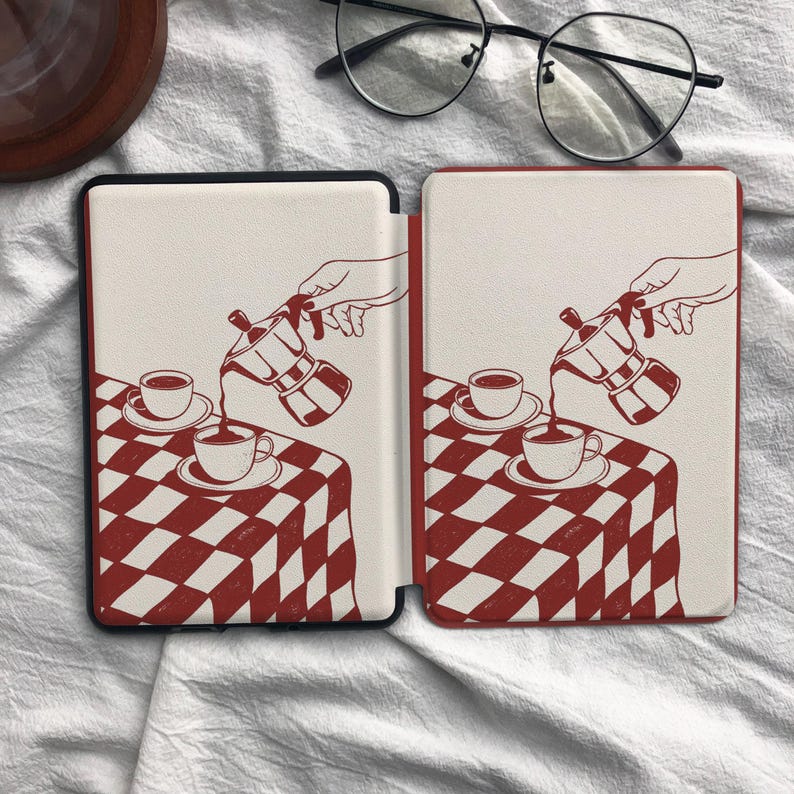 May include: A protective e-reader cover featuring a red and white checkered tablecloth pattern. The design displays a hand pouring coffee from a moka pot into a cup, with a matching saucer and cup set resting on the table surface.