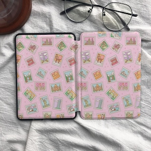 May include: A protective e-reader cover featuring a repeating pattern of colorful postage stamps depicting global landmarks on a light pink background. The design includes illustrations of the Eiffel Tower, the Statue of Liberty, and tulips.