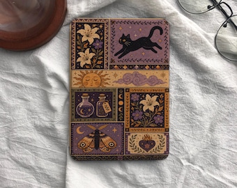 Pode incluir: Uma capa retangular para e-reader com uma grade de ilustrações em roxo, dourado e preto. O design inclui um gato preto a saltar, lírios, um sol, nuvens, frascos de poções, uma traça e um coração em chamas sobre um fundo escuro.