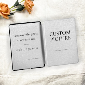 May include: Open Kindle or iPad case with the text "Send over the photo you wanna use, stick to a 3:4 ratio" on the left side. The right side reads "CUSTOM PICTURE" and "(Fits Kindle/ Kobo/ iPad)". The case is open on a white surface.