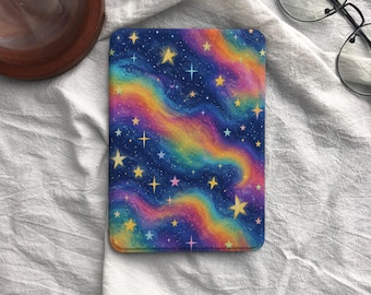 Può includere: Una custodia rettangolare per e-reader con una vivace stampa galassia caratterizzata da bande vorticose di colori blu, viola, rosa e giallo. La superficie è decorata con numerose stelle gialle e bianche di varie dimensioni e forme.