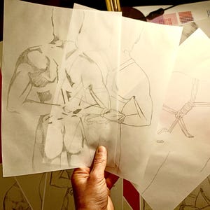 Pu&ograve; includere: Una mano tiene in mano diversi fogli di carta traslucida con schizzi a matita della forma umana. I disegni raffigurano figure in varie pose, con un focus sui dettagli anatomici e le proporzioni del corpo. Gli schizzi sono in bianco e nero.