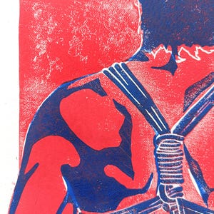 Pu&ograve; includere: Una stampa linoleografica raffigurante una figura nei toni del rosso e blu. L'opera d'arte mostra una spalla e un braccio, con elementi simili a corde e uno sfondo strutturato. La tavolozza dei colori &egrave; audace e grafica.