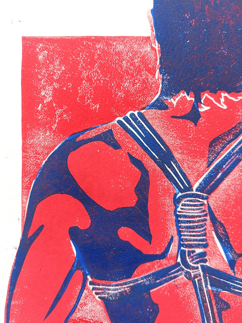 Pu&ograve; includere: Una stampa linoleografica raffigurante una figura nei toni del rosso e blu. L'opera d'arte mostra una spalla e un braccio, con elementi simili a corde e uno sfondo strutturato. La tavolozza dei colori &egrave; audace e grafica.