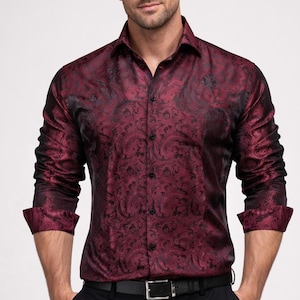 以下が含まれることがあります： バーガンディ色のペイズリー柄のシャツ。長袖でボタンダウンカラー。黒のペイズリー模様があり、黒いパンツと黒いベルトと合わせています。