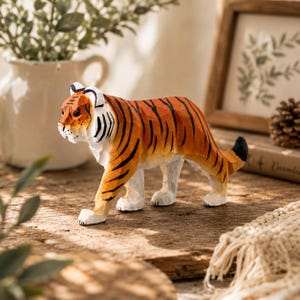 Può includere: Una statuetta di tigre in legno intagliata a mano con una superficie strutturata e sfaccettata. La tigre è dipinta in arancione vivace con strisce nere distintive, parti inferiori bianche e una punta della coda nera, in posa camminante.