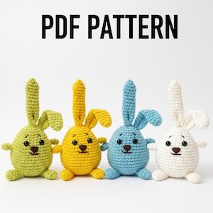 Puede incluir: Cuatro conejitos de Pascua de ganchillo en verde, amarillo, azul y blanco. Cada conejo tiene un cuerpo redondeado, orejas largas y una pequeña nariz marrón. El texto "PDF PATTERN" se muestra encima de los conejos.