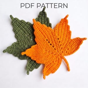Könnte beinhalten: Zwei gehäkelte Ahornblätter, eines in Olivgrün und eines in leuchtendem Orange, werden mit dem Text PDF PATTERN oben angezeigt. Die Blätter weisen eine detaillierte gestickte Textur mit einer Mittelrippe und spitzen Lappen aus Garn auf.