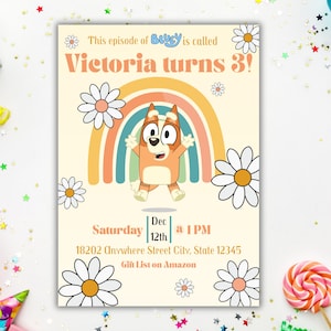 May include: A birthday invitation featuring a cartoon dog character, a rainbow, and daisies. The text reads "Victoria turns 3!" with the date and time of the party. The invitation is on a cream background with decorative elements.