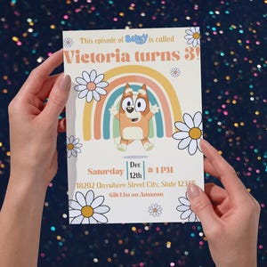 May include: A birthday invitation featuring a cartoon character and a rainbow design. The text reads "Victoria turns 3!" with event details. Daisies surround the design, with the words "This episode of Bluey is called" at the top.