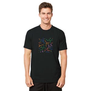 May include: Black t-shirt with a colorful abstract design. The design features a square pattern of various colored lines, including orange, green, blue, and purple. The t-shirt is made of a soft material.