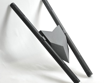 May include: A black, matte-finished object consisting of two parallel, cylindrical rods connected by a central, triangular, wedge-shaped piece. The rods feature textured, ribbed grip sections at both ends, and the entire structure is rigid.