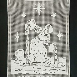 May include: White crocheted wall hanging with a detailed image of a figure pouring water, surrounded by stars. The text "THE STAR" is at the bottom. The piece is made of a grid of small squares, creating a pixelated effect.