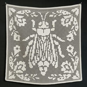May include: A square off-white crochet wall hanging featuring a central insect motif surrounded by floral patterns. The piece is crafted using a grid-like filet crochet technique, creating a detailed graphic design of a beetle and surrounding flowers.