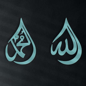 Puede incluir: Dos piezas de arte mural de color turquesa en forma de lágrima, con caligrafía árabe. La obra de arte está montada en una pared oscura, con un sofá y objetos decorativos en el fondo. La caligrafía es un elemento de diseño prominente.