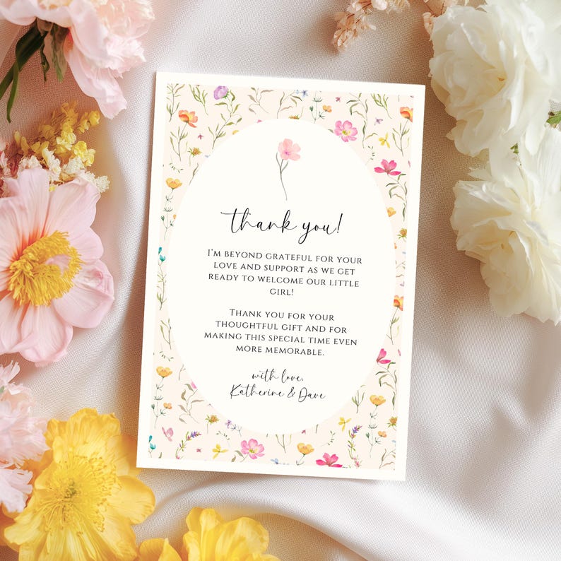 May include: A floral-themed thank you card with the text "thank you!" in elegant script. The card features a cream background with a delicate floral border and an oval design in the center. The text expresses gratitude.
