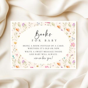 May include: A rectangular baby shower invitation with floral accents. The invitation features the text "Books for Baby" in elegant script, with additional text encouraging guests to bring a book instead of a card.