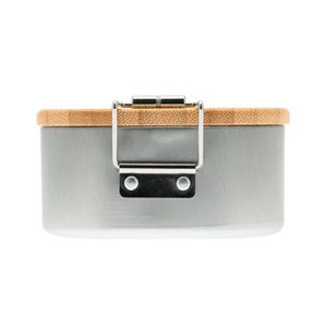 May include: A cylindrical container with a smooth, matte gray metal body and a light brown bamboo lid. The lid is secured by a silver-colored metal latch mechanism attached to the side of the container with two visible rivets.