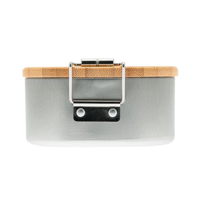 May include: A cylindrical container with a smooth, matte gray metal body and a light brown bamboo lid. The lid is secured by a silver-colored metal latch mechanism attached to the side of the container with two visible rivets.