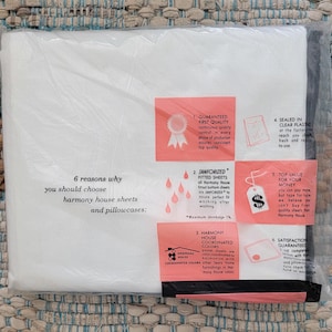 May include: A package of white Harmony House sheets and pillowcases enclosed in clear plastic. The packaging features a list of six reasons to choose the product, accompanied by six coral-colored informational boxes with icons and descriptive text.