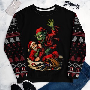 May include: Black sweatshirt with a graphic of a green creature attacking Santa Claus. The sleeves have a red, white, and gray Christmas pattern. A sack of presents is open on the ground.