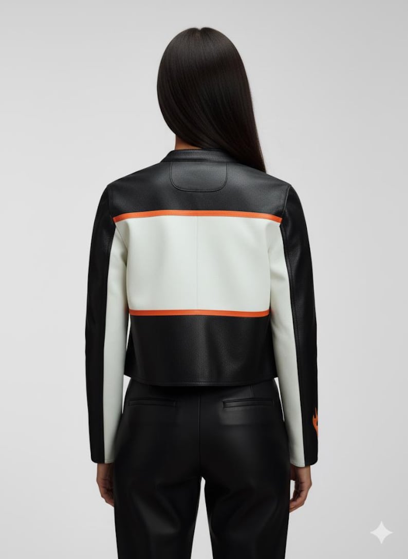 May include: Black and white leather jacket with orange stripe accents. The jacket features a white panel across the back with an orange stripe above and below. The sleeves and shoulders are black. The jacket is cropped.