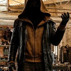 May include: A hooded jacket ensemble featuring a tan zip-up hoodie layered beneath a black leather coat. The outfit includes dark trousers and black gloves. The hood is pulled up, obscuring the face, while the jacket features a structured collar.