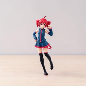 May include: A standing anime-style figurine with bright red hair styled in twin tails. The character wears a dark blue collared shirt with red buttons, a matching pleated skirt with a red hem, black thigh-high stockings, and a small red tail accessory.