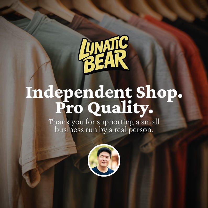May include: A row of t-shirts in various colors, including beige, green, gray, and red, hanging on wooden hangers. The image features the text "LUNATIC BEAR" and "Independent Shop. Pro Quality."