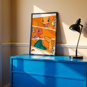 May include: A framed vertical poster featuring a three-part orange graphic illustration of the Pokémon characters Charmander, Charmeleon, and Charizard, with Japanese text and the names Charmander, Charmeleon, and Charizard printed at the bottom.