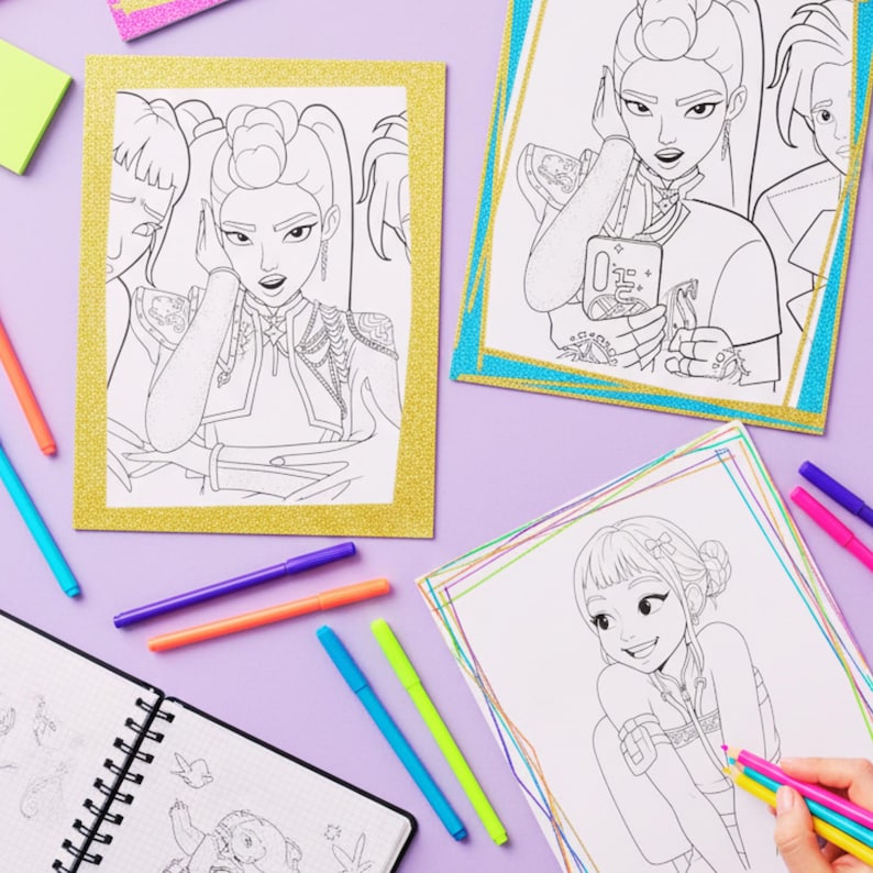 May include: Coloring pages featuring line art illustrations of stylized female figures, with gold and teal glitter borders. Colored markers in various colors and a sketchbook are also present, all on a purple surface.