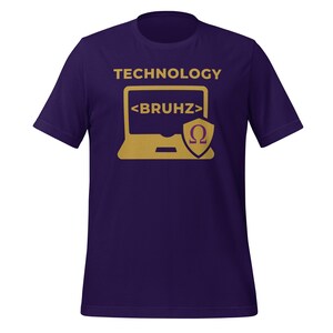 May include: A purple t-shirt featuring a gold graphic. The design includes the word "TECHNOLOGY" above a laptop image with the text "<BRUHZ>" and a shield with the Greek letter omega. A short-sleeved tee.