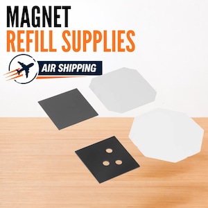 Op de afbeelding: Een set magneetnavulbenodigdheden met twee vierkante zwarte metalen platen, waarvan één met drie ronde gaten, en twee witte achthoekige vormen. De afbeelding bevat de tekst MAGNET REFILL SUPPLIES en een afbeelding van een vliegtuig.