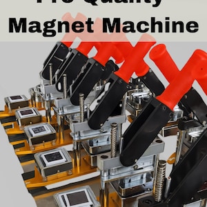 Op de afbeelding: Een Pro-Quality magneetmachine met een feloranje handvat, een zwarte hendel en een basis van zilver- en goudkleurig metaal. Het apparaat heeft een veermechanisme voor het persen van magneten, met meerdere eenheden in een rij op een vlak oppervlak.