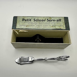 Può includere: Un'utensile da portata vintage "Petit Scissor Serv-all" con finitura cromata, progettato per sardine, antipasti e altri alimenti. L'utensile è nella sua scatola originale, che include testo sul suo scopo e origine.