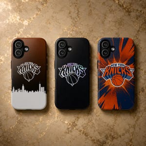 May include: Three rectangular mobile phone cases featuring the New York Knicks basketball team logo. The left case has a brown-to-white gradient with a city skyline. The center case is solid black. The right case has an orange and blue sunburst design.