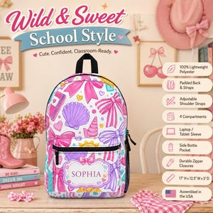 Peut inclure: Un sac à dos blanc avec un motif de nœuds, coquillages et cœurs roses et violets. Le sac à dos a une poignée et une fermeture éclair noires. Il porte le nom "SOPHIA" et mesure 43cm H x 32cm L x 13cm P. Le texte "Wild & Sweet School Style" est en haut.