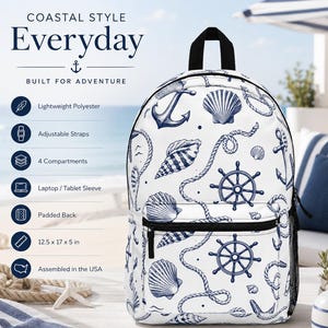 May include: White backpack with a navy blue nautical design featuring anchors, seashells, and ship wheels. The backpack has adjustable straps, four compartments, and a laptop sleeve. It measures 12.5 x 17 x 5 inches and is assembled in the USA. The text on the backpack says "COASTAL STYLE Everyday BUILT FOR ADVENTURE".