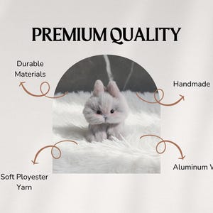 May include: A handmade, gray bunny figurine made with soft polyester yarn and durable materials. The bunny has pink ears and is sitting on a white, fluffy surface. The image includes the text "Premium Quality".