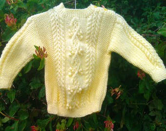 Child's boy girl toddler handknit yellow aran cable sweater with shoulder opening.