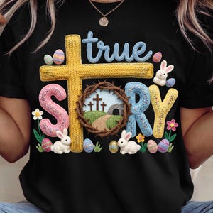 May include: Black t-shirt with a colorful Easter design. The design includes the words "true story" with a cross, a crown of thorns, Easter eggs, and bunnies. The letters are in various colors.