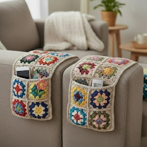 Può includere: Due organizer per braccioli all'uncinetto con quadrati floreali colorati. Ogni organizer ha una tasca per riporre oggetti come telefono, occhiali e telecomando. Gli organizer sono beige con vivaci quadrati rossi, blu, gialli e verdi.