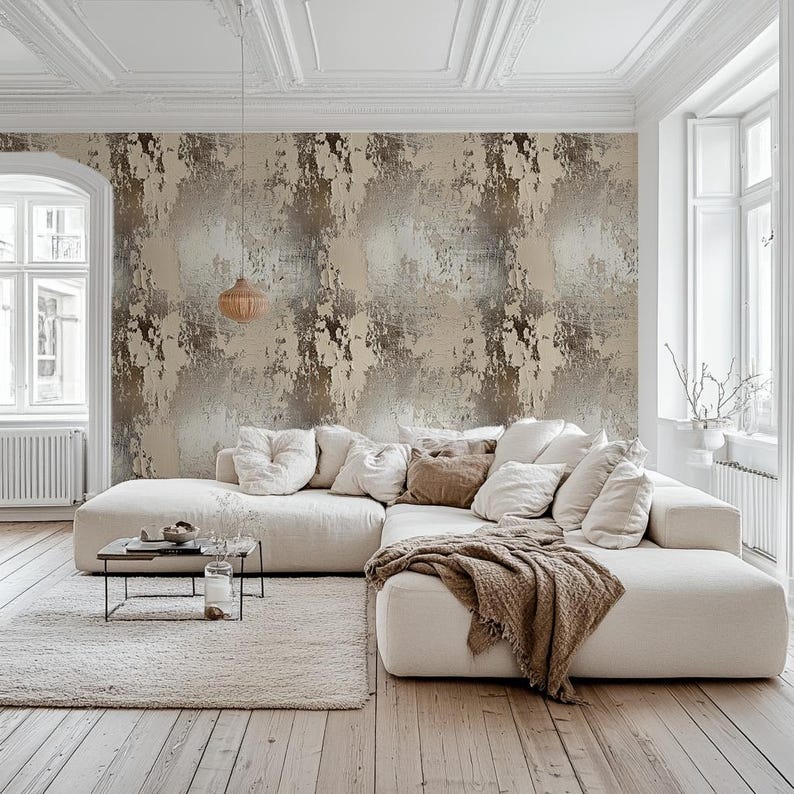 May include: A modern living room with a large, off-white sectional sofa, a textured rug, and a small black metal coffee table. The wall features a distressed wallpaper in shades of beige and brown. A woven pendant light hangs above the coffee table.